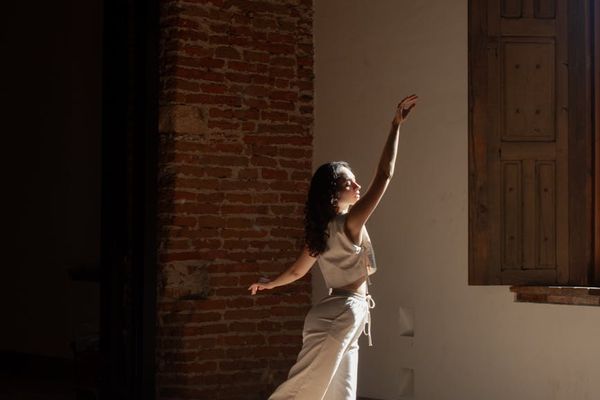 Person practicing mindful movement in a bright, spacious room.